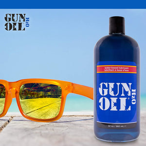 Gun Oil H2O logo on the top left of the image. with sky blue background, yellow/orange pair of sunglasses laying on tiles, and a Bottle of water-based lubricant Gun Oil H2O 32 oz / 960 mL