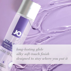 A bottle of JO XTRA Silky Personal Lubricant Ultra-Thin Silicone Original laying in lubricant. Long-lasting glide, silky soft-touch finish, designed to stay where you put it.