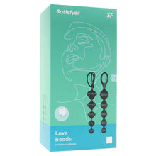 Load image into Gallery viewer, Front of the package for Satisfyer Love Beads Soft Silicone Beads, on the right side are the two black soft silicone beads, vertically placed with the tips pointing down. On the right side of the package is written Super Soft Silicone Beads, and a tag sticking out from the back with the SF logo on it.