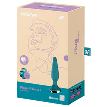 Load image into Gallery viewer, Front of the package for the Satisfyer Plug-ilicious 1 Plug Vibrator, at the top of the package are the Satisfyer logos, on the left side is an icon for dual motors, and below is an icon with smart devices + Free App, for Satisfyer Connect App integration, on the right side of the package is the product, and on the bottom right is the bluetooth logo, and a 15 year guarantee mark. On the right side of the package is written Plug Vibrator, on the bottom Get your free Satisfyer Connect App
