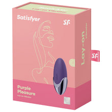 Load image into Gallery viewer, Front of the package from the top are the Satisfyer logos, on the bottom left is the product name Purple Pleasure Lay-on Vibrator, on the right side of the product facing up and to to the side, and on bottom right is the 15 year guarantee mark. On the right side of the package is written Lay-on Vibrator, and from the back is a tag with the SF logo sticking out.