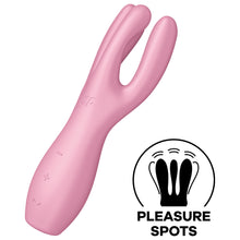 Load image into Gallery viewer, Satisfyer Threesome 3 Vibrator diagonally facing front and to the left, with the controls visible on the lower part of the handle marked by -, + and a horizontal wave, on the top is engraved SF logo. On the bottom right of the image is an icon for Pleasure Spots.
